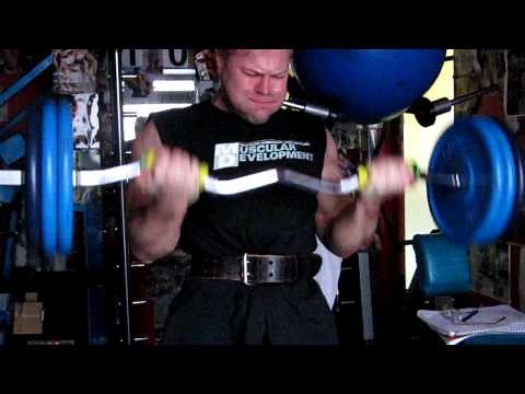 Michael Gundill performs barbell biceps curls with an EZ bar