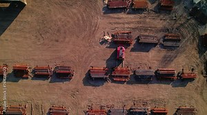Forklift Loading rusted steel bar on industrial yard full of staked metal bars. Detroit, Michigan, USA