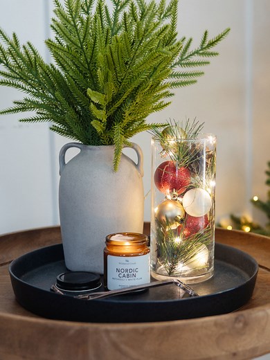 This is such a simple way to create a festive centerpiece: a Dollar Tree hurricane vase, ornaments, pinecones, and string lights! Let me know if you'd try this easy DIY Christmas centerpiece idea. #thediymommy #dollartreediy #christmasdiy #dollartreefinds