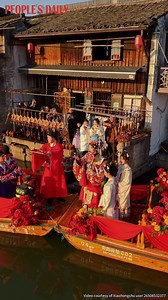 Participants in traditional Chinese wedding attire glide along the river in black-awning boats, performing a time-honored water-town wedding ceremony that draws visitors in Anchang ancient town of Shaoxing, east China’s Zhejiang Province. | Beautiful China