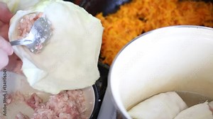 Cooking cabbage. A man takes a spoon stuffing and wrapped in cabbage leaves. Then he puts into the pot. Video shot on the Canon 70D.