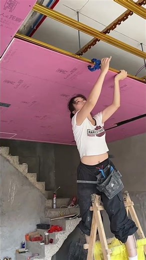 Female carpenter making suspended ceiling