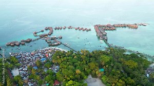 Aerial hyper-lapse of Sabah's Mabul Island, an captivating scenery of the Bajau community and the Water Village Resort, presenting a dynamic tapestry of life in this coastal haven of Malaysia.