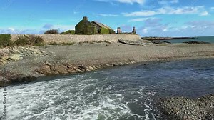 Cemlyn Bay on the Isle of Anglesey in Gwynedd off the north Wales coast. Wylfa Nuclear Power Station is on the headland in the distance.