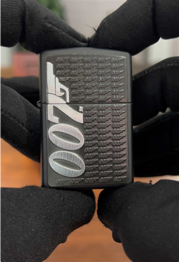Zippo James Bond 007 Ocak 2018 üretimi Bradford, Pennsylvania – Made in U.S.A. Bu model, 007 James Bond serisinin modern ve güçlü tasarımlarından biridir. Mat siyah kasa üzerinde tekrarlayan tabanca silüeti desenleri yer alırken, ön yüzde büyük ve kabartmalı 007 logosu dikkat çeker. Minimal ama sert duruşu, Bond karakterinin gizemli ve karizmatik kimliğini yansıtır. Lisanslı James Bond ürünü olan bu Zippo, hem film koleksiyonerleri hem de tematik Zippo biriktirenler için vitrinlik bir parçadır. 