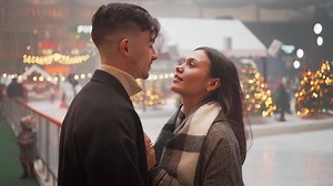 Cheerful young couple kissing and embracing on Christmas night.