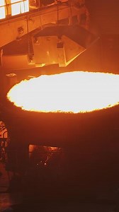 Witness the intense and mesmerizing molten metal pouring process occurring in a foundry setting. Stock Clip