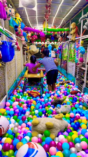 With help of friend pushing the slide down the slide Sliding and rolling on colorful balls exciting