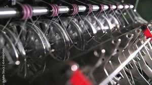 Close up of textile machine in slow motion. Fibre thread lines on the weaving loom machine. A loom machine for clothing or woven clothes. Weaving machine for garment industry.
