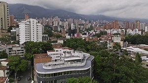 Premium stock video - Medellin colombia aerial v3 low drone flyover manila, lalinde and el poblado upscale neighborhoods capturing street traffics and hillside high rise cityscape - shot with mavic 3 cine - november 2022