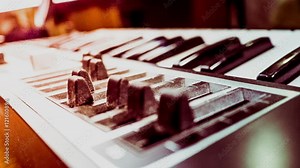 Keyboard of a synthesizer with animated sliders. Closeup of musical equipment .