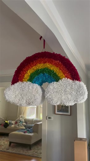 We made this pinata for an elementary school art auction on Portland, OR. 1st graders helped apply thousands of tissue paper puffs to this handmade cardboard frame! The effect produces magic! #pinatas #diy #elementaryschool #schoolauction #art #kidart #rainbow