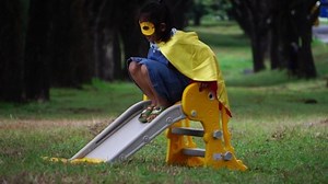 Children wearing masks and capes playing in the park