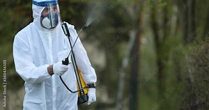 Footage of a person in a pandemic suit disinfecting an open and exposed area...