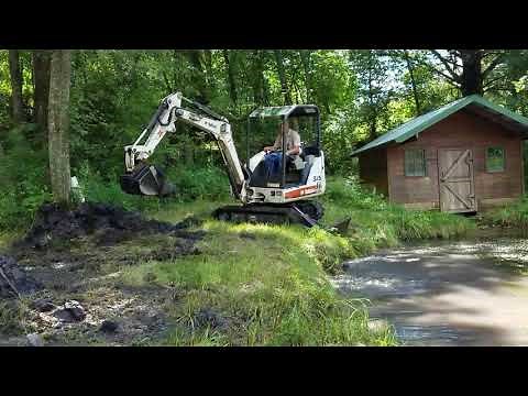 Bobcat mini excavator 325 digging out pond