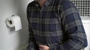 Constipated man in restroom rubbing painful stomach | Premium Stock Video Footage