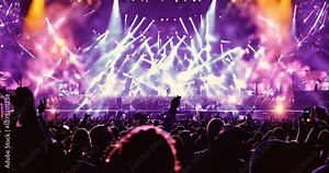 A lively concert crowd illuminated by bright stage lights at a live event, such as a concert or halftime show, set in a sports stadium, generated by AI.