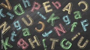 Uppercase and lowercase Latin color letters are written in chalk on a school blackboard.