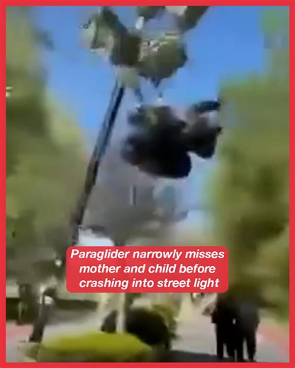 Paraglider narrowly misses mother and child before crashing into street light