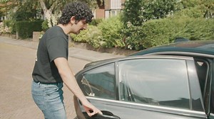 Man hailing a cab on street and gets into the back
