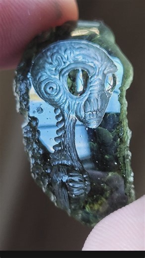 20.1 carat moldavite I intaglio carved an alien head onto. I cut and polished one face onto the piece and left the sides and back its natural rough texture. moldavite is a well known dark green tektite created by a meteor impact on the Czech Republic. I only see it fitting to carve alien scenery onto this cosmic green material. do you own any moldavite? #forgedelements #fyp #moldavite #alien #martian | Jack Hoque