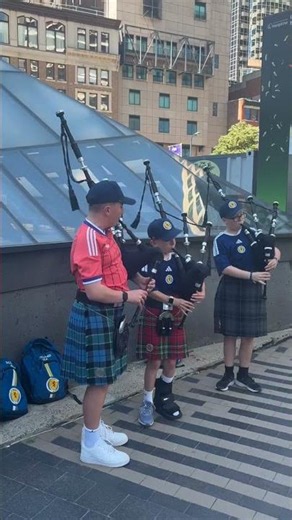 Young Scottish bagpipers perform at South Station before World Cup
