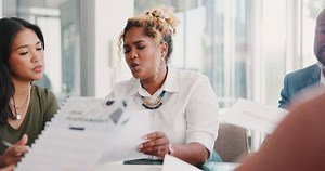 Business people, office meeting and planning while reading schedule, report and finance graph for discussion about budget, growth and development of company. Men and women team talking b2b proposal