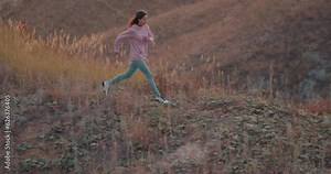 active fit female runner training jogging outdoors in beautiful mountain nature landscape Slow motion, girl runs down the hill, health and body care. wellness Lifestyle Hobby Leisure Motivation