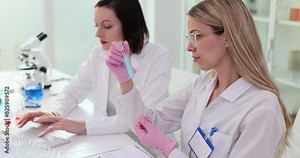 Two scientists holding a blue test tube working in laboratory