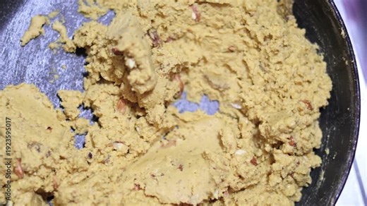 Chef stirring golden roasted gram flour dough for authentic homemade Indian sweets and desserts.