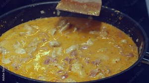 Closeup view: Rich creamy chicken curry simmers in pan on hot stove
