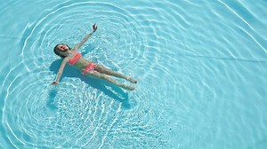 Adorable happy little girl enjoy swimming in the pool. Family summer vacation, kid relax at pool.