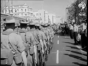 Sydney, Australia 1966. The Australian Task Force departs for Vietnam. Several shots of Australian troops marching along the crowded streets of Sydney on their way to Sydney harbour. Crowds applauding and cheering. Troops marching. Prime Minister of Australia Harold Holt boards a Qantas aircraft - he is going to Vietnam to visit Australian troops fighting there. The troopship HMAS Sydney at the quay with crowds on the dock. An overhead shot of the troopship HMAS Sydney as she moves away. A small
