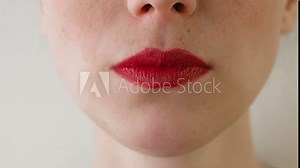 Woman with red lips eats strawberries. Mouth close-up. Front view.