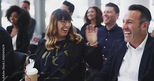 The speaker is doing well at keeping the audience entertained. 4k video footage of a group of businesspeople laughing during a conference.