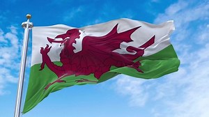 Flag of Wales realistic waving in the wind with sky background (Perfect Loop)