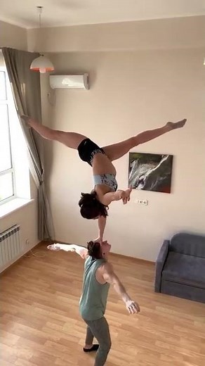 Woman Does Handstand on Partner's Head While He Sits Down And Stands Back Up - 1284302