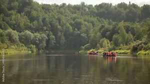 Large Rubber Rafts with People Floating on a Wide River Through the Forest. Rafting is Recreational Outdoor Activity which use an Inflatable Raft to Navigate a River or Other Body of Water.