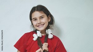 Shy little smiling happy girl standing . Cute teenage joyful girl being shy on white background. emotions are big kids concept lifestyle