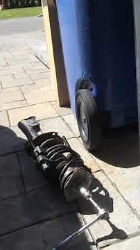 Strut mount bolt removal (with coil spring compressed)