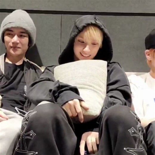 huening kai hugging a pillow