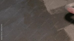 A worker applies the primer to the concrete floor with a roller. Priming Concrete floor before laying tiles on it, the final preparatory stage for strengthening the surface
