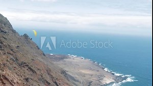 Freestyle acro paragliding along the cliff