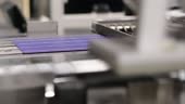 Closeup detail of a solar panel making machine.