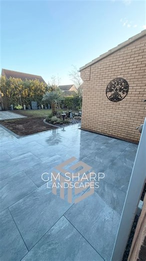 GM Sharp Landscapes on Instagram: "A lovely St Ives job wrapped up this week 🪏 We removed the old concrete, paving and decking, excavated to 200mm, then installed a new subbase with membrane and compacted Type 1. Finished with 50m² of 900x600 Volcanic Grey porcelain slabs, charcoal block edging, a new larger composite decking area, and 14mm Basalt chippings for the French drain. Lawn topped up with fresh soil and grass seed to complete the transformation. 🌱 @bannold_supplies @azpectsuk @avs_fe