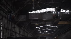 Close up of an indoor factory overhead crane transporting heavy industrial trolley. Clip. View inside of working shop at the mining plant.