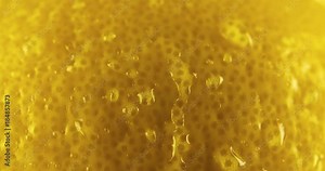 Fresh Lemon skin peel texture close up macro background with water droplet flowing down. Citrus Organic Healthy Food 4K video