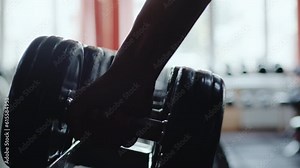 Male hand taking bodybuilding dumbbells in gym club. Closeup man hands taking weight lifting in sport club. Fitness guy having sport training in fitness gym
