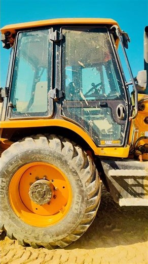 Village Land Preparation: JCB Backhoe Loader Working Hard in Wet Soil