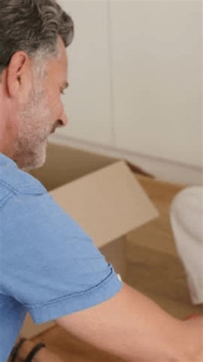 clip-4046475095-vertical-video-opening-box-kneeling-older-man